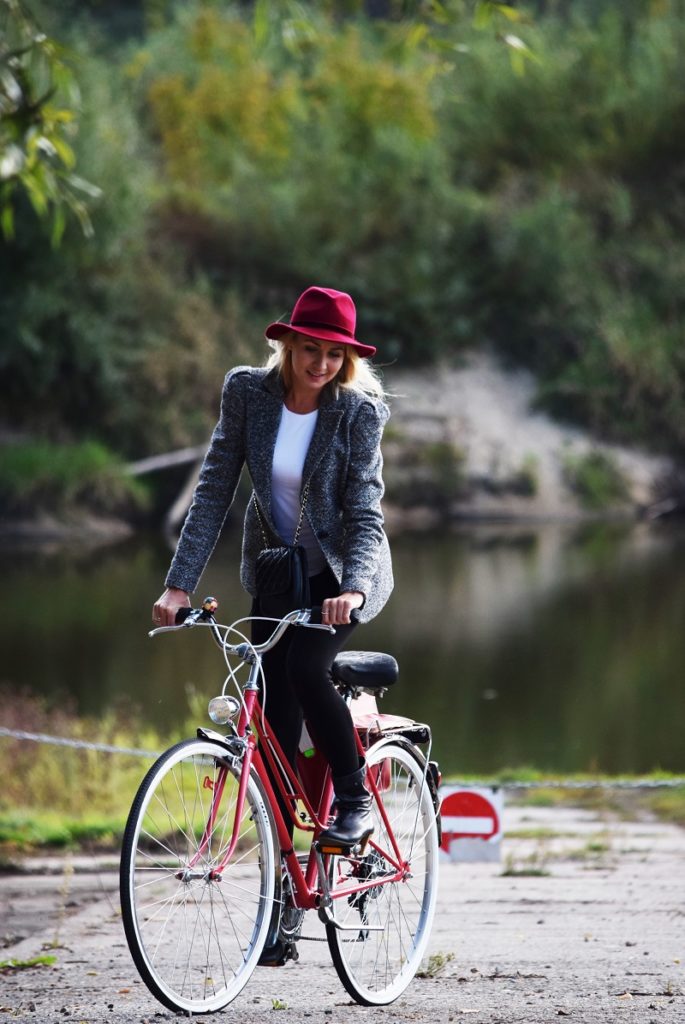modelka w kapeluszu na rowerze parku